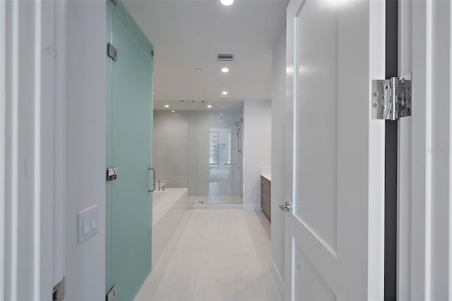 bathroom with tile patterned flooring, vanity, and plus walk in shower