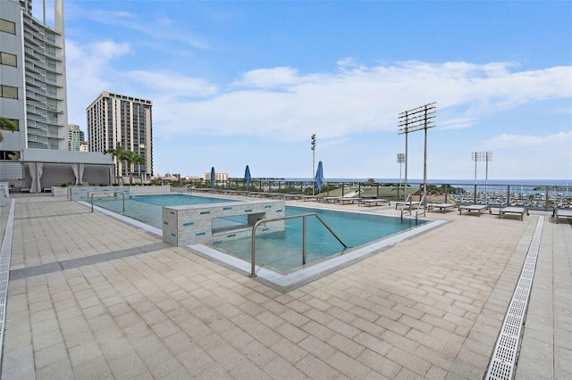 view of swimming pool featuring a jacuzzi and a patio