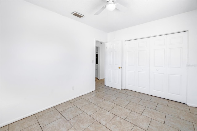 unfurnished bedroom featuring ceiling fan, a closet, and light tile patterned floors