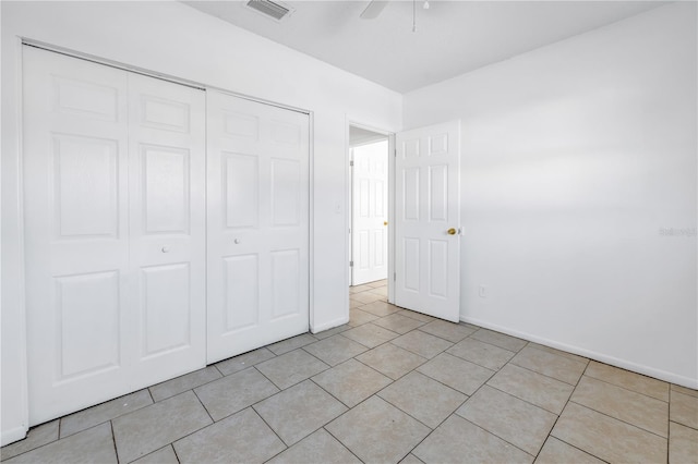 unfurnished bedroom with ceiling fan, a closet, and light tile patterned floors