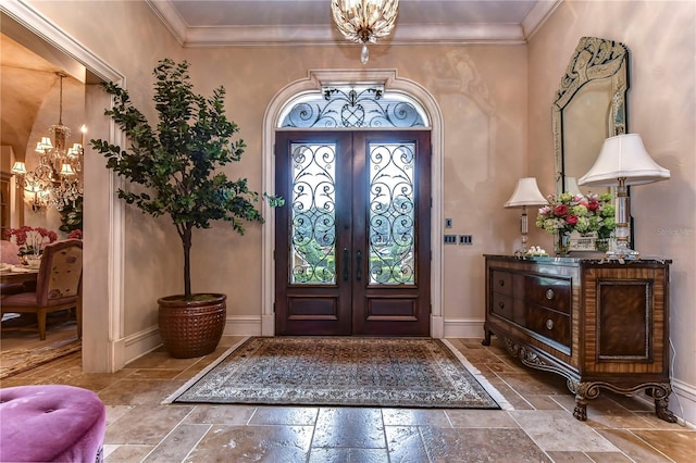 entryway with french doors, ornamental molding, and a chandelier