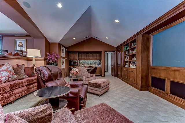 home theater featuring lofted ceiling, ornamental molding, and light colored carpet