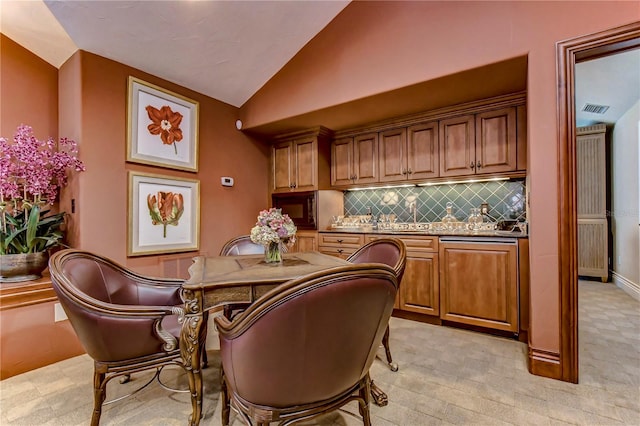 bar featuring backsplash, light carpet, and vaulted ceiling