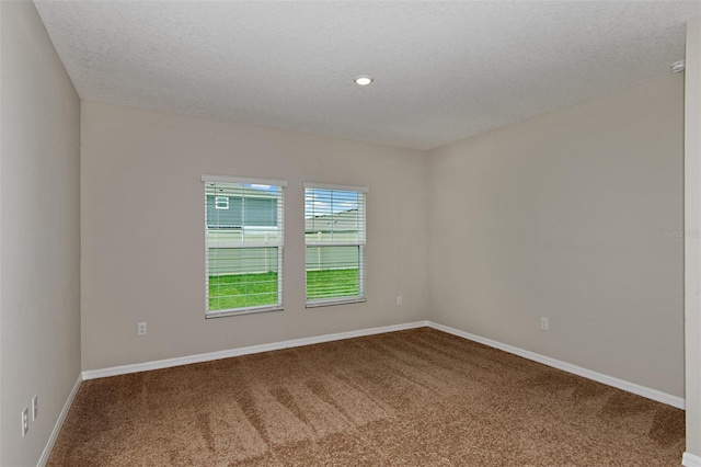 carpeted spare room with a textured ceiling