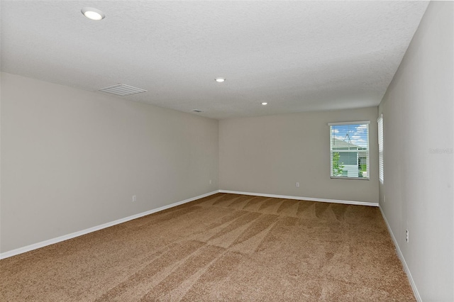 carpeted spare room featuring a textured ceiling