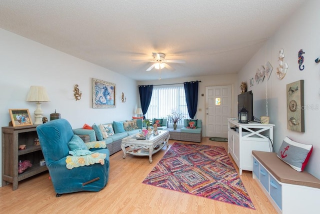 living room with a textured ceiling, light hardwood / wood-style floors, and ceiling fan