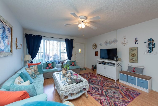 living room featuring hardwood / wood-style floors, a textured ceiling, and ceiling fan