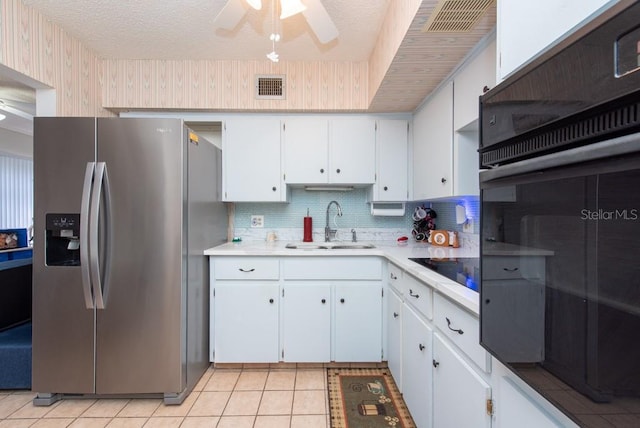 kitchen featuring sink, black appliances, white cabinets, and light tile patterned flooring