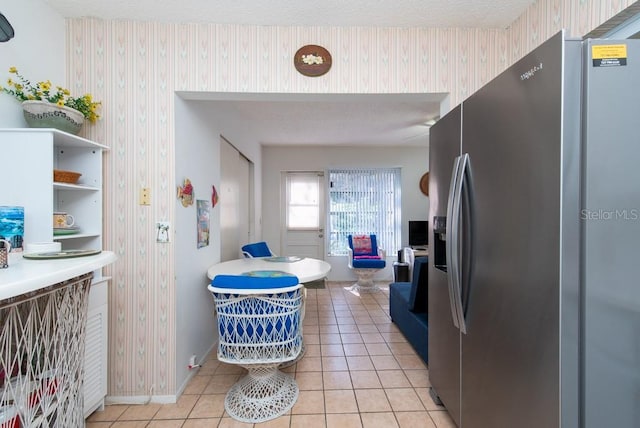 kitchen featuring light tile patterned floors and stainless steel fridge with ice dispenser