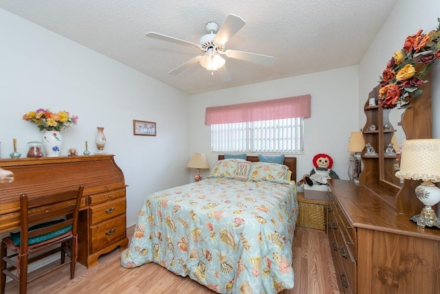 bedroom with light hardwood / wood-style floors, a textured ceiling, and ceiling fan