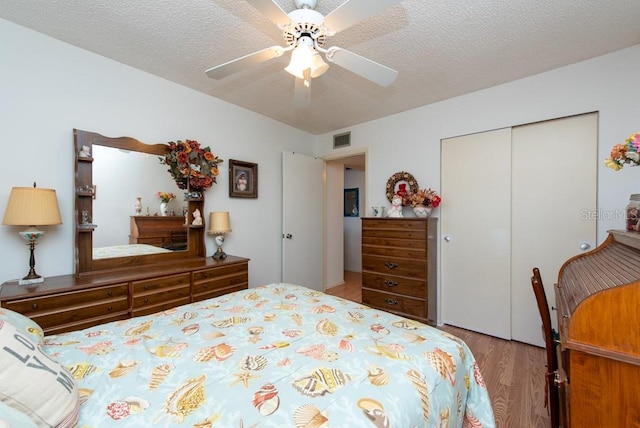 bedroom featuring a closet, ceiling fan, a textured ceiling, and light wood-type flooring