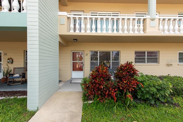 view of exterior entry with a balcony