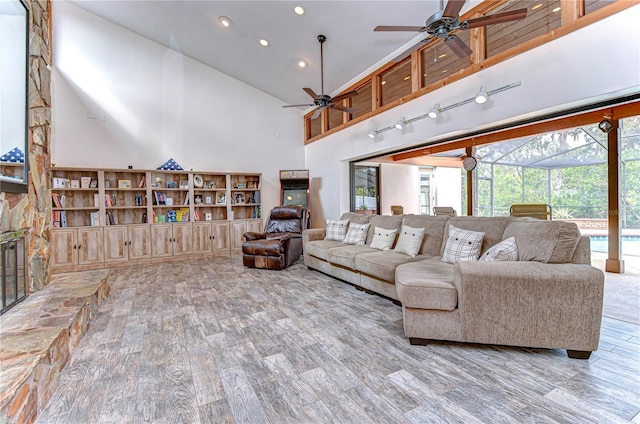 living room featuring hardwood / wood-style flooring, ceiling fan, and high vaulted ceiling