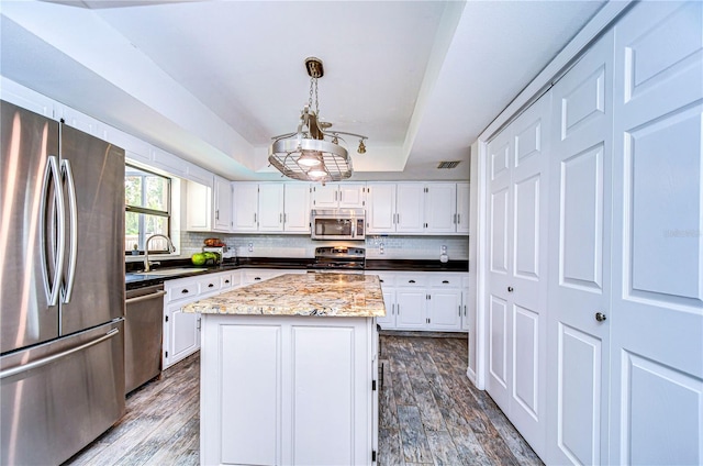 kitchen with white cabinets, appliances with stainless steel finishes, and a center island