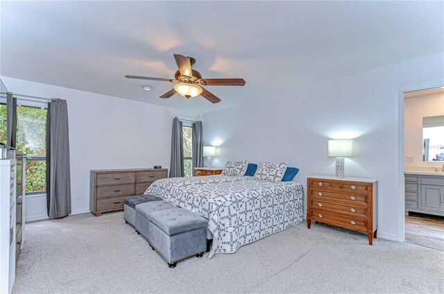 carpeted bedroom with multiple windows, ceiling fan, and connected bathroom