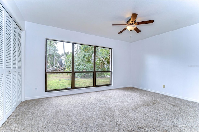 unfurnished room with ceiling fan and carpet flooring