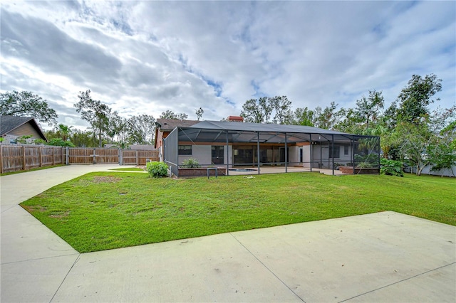 rear view of property with glass enclosure, a yard, and a patio