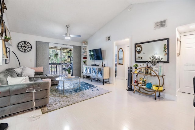 living room featuring hardwood / wood-style floors, high vaulted ceiling, and ceiling fan