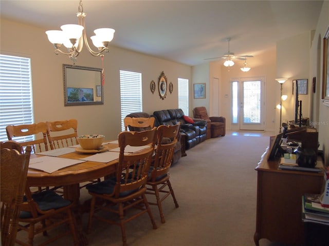 dining area with ceiling fan with notable chandelier and carpet floors