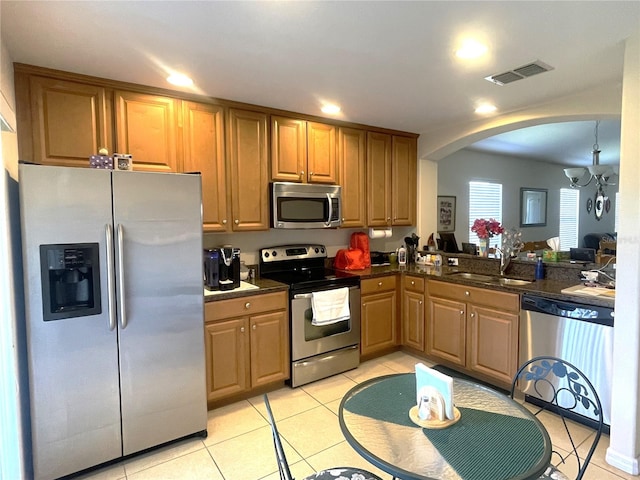 kitchen with sink, light tile patterned floors, stainless steel appliances, and an inviting chandelier