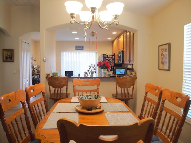 18833 Bent Pine Dr, Hudson, FL 34667 - dining room featuring arched walkways, a chandelier, and recessed lighting