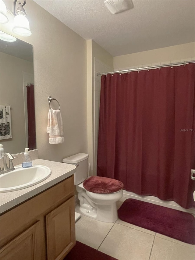 bathroom with vanity, tile patterned flooring, a shower with shower curtain, toilet, and a textured ceiling