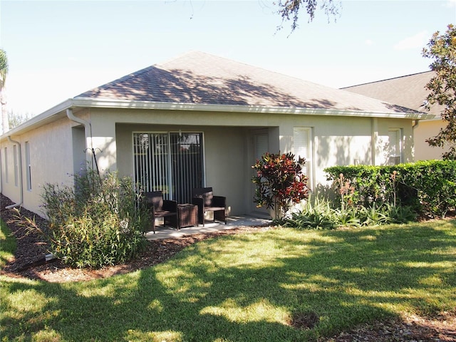 rear view of house featuring a lawn and a patio area