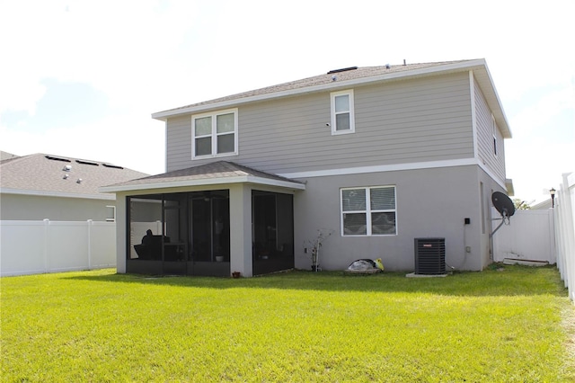 rear view of property with a sunroom, a lawn, and central AC unit