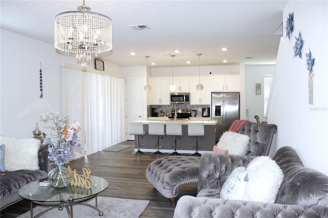 living room with a chandelier and dark hardwood / wood-style floors