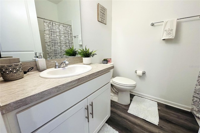 bathroom featuring vanity, wood-type flooring, and toilet