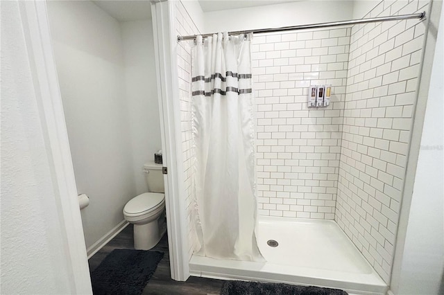 bathroom featuring toilet, hardwood / wood-style floors, and walk in shower