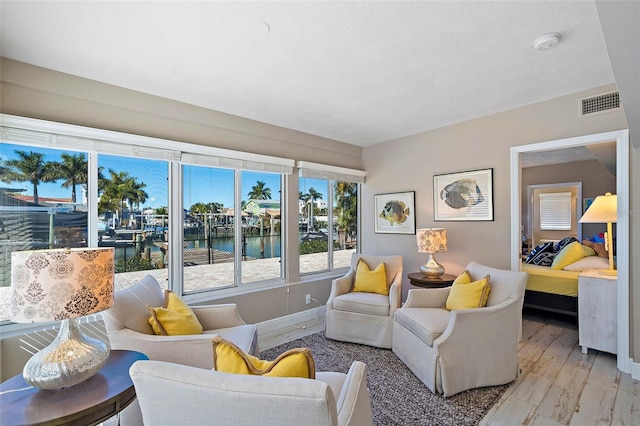 living room featuring light hardwood / wood-style flooring and a water view