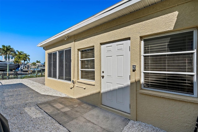 doorway to property with a patio area and a water view