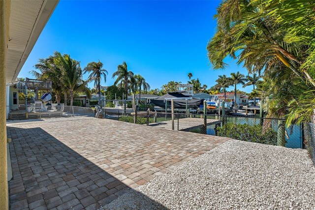 exterior space featuring a playground, a boat dock, and a water view