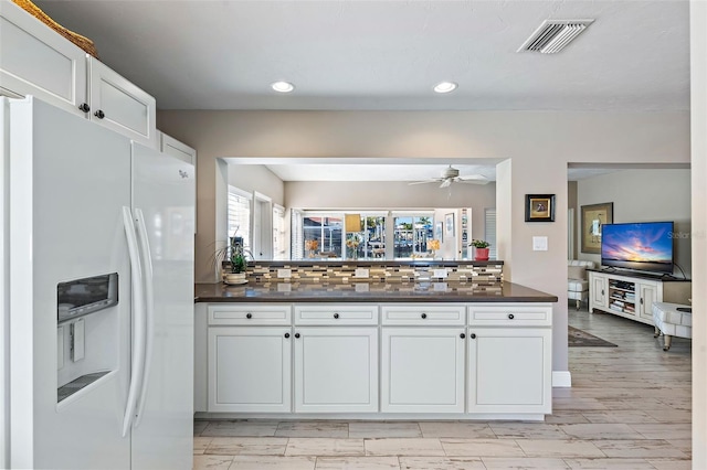 kitchen with white cabinetry, ceiling fan, tasteful backsplash, and white fridge with ice dispenser