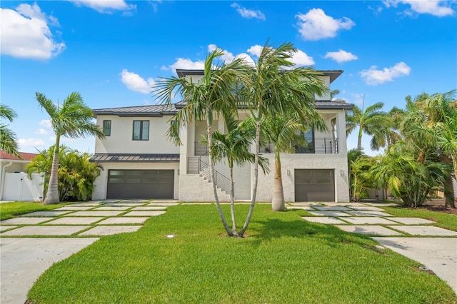 view of front of property with a balcony, a front lawn, and a garage