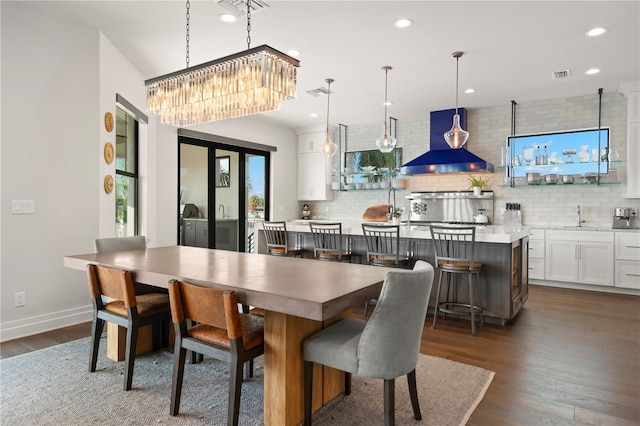 dining room with dark hardwood / wood-style floors, an inviting chandelier, and sink