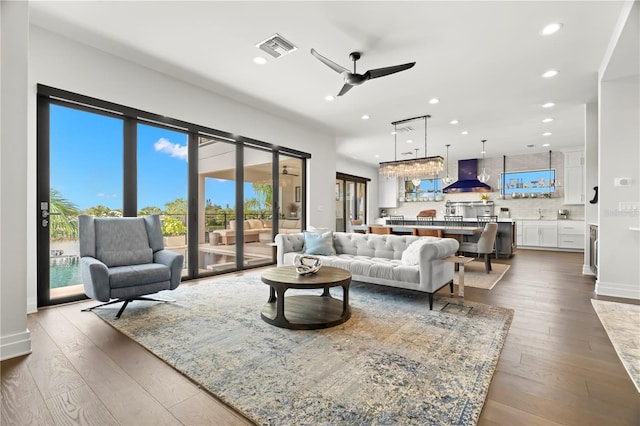 living room with ceiling fan and dark hardwood / wood-style flooring