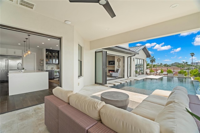 view of pool featuring an outdoor living space, ceiling fan, and a patio area