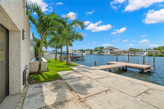 view of dock with a water view and a yard