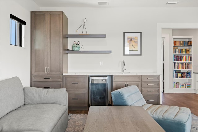 interior space with built in features, dark hardwood / wood-style floors, wine cooler, and sink