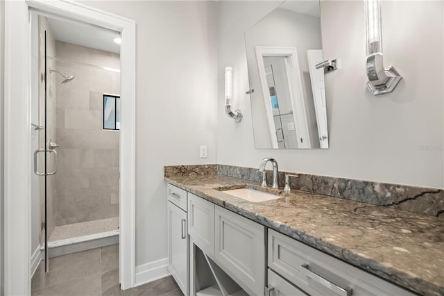 bathroom featuring tile patterned floors, vanity, and a shower with shower door