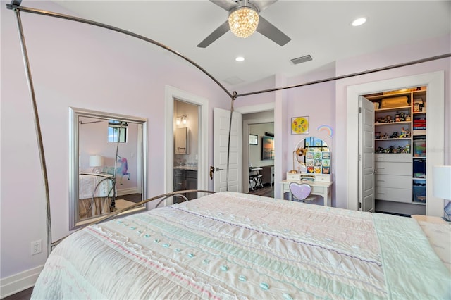 bedroom featuring connected bathroom, ceiling fan, vaulted ceiling, a walk in closet, and a closet