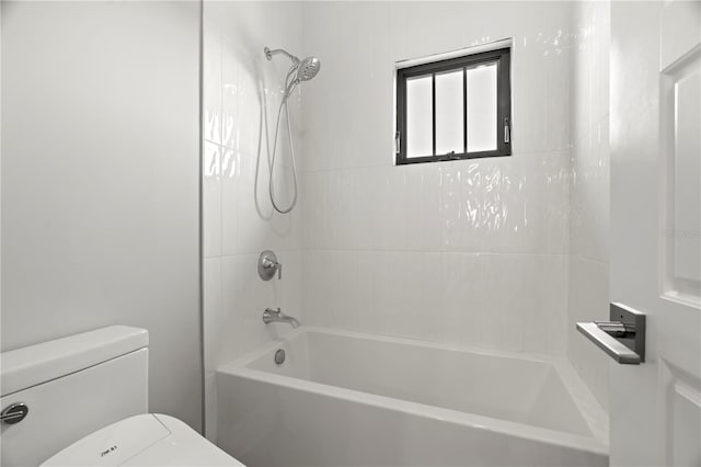 bathroom with tiled shower / bath combo and toilet