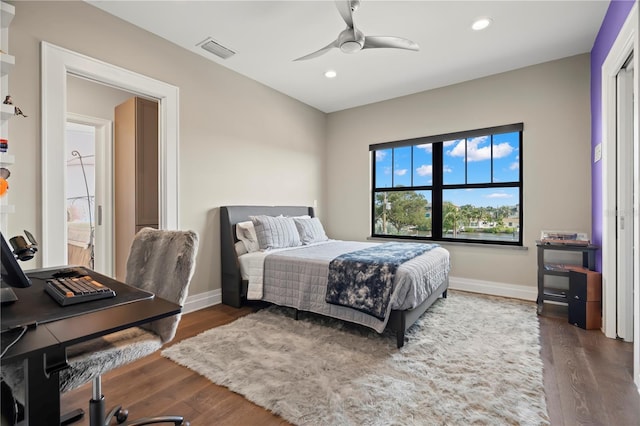 bedroom with dark hardwood / wood-style floors and ceiling fan