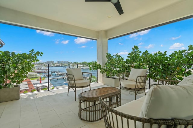 balcony featuring a water view and ceiling fan