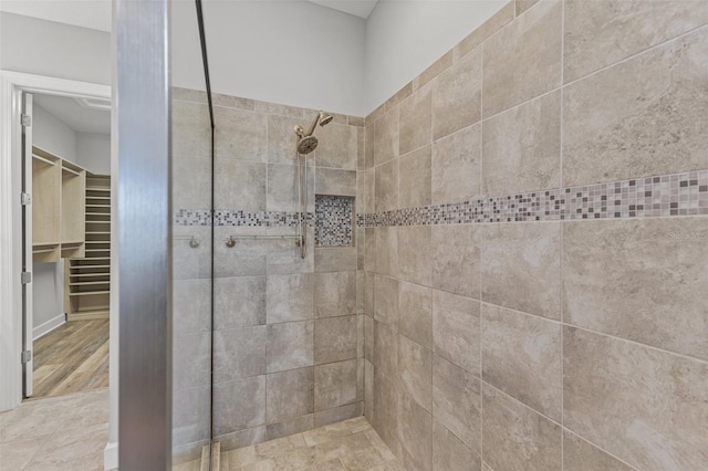 bathroom featuring a tile shower and wood-type flooring