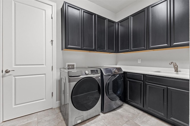 clothes washing area with sink, independent washer and dryer, and cabinets