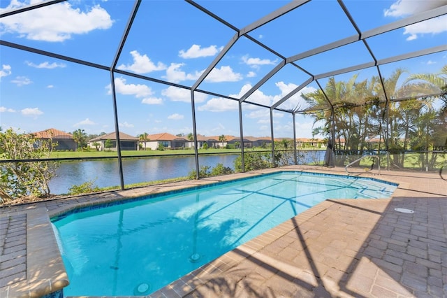 view of swimming pool with a water view, a patio, and glass enclosure