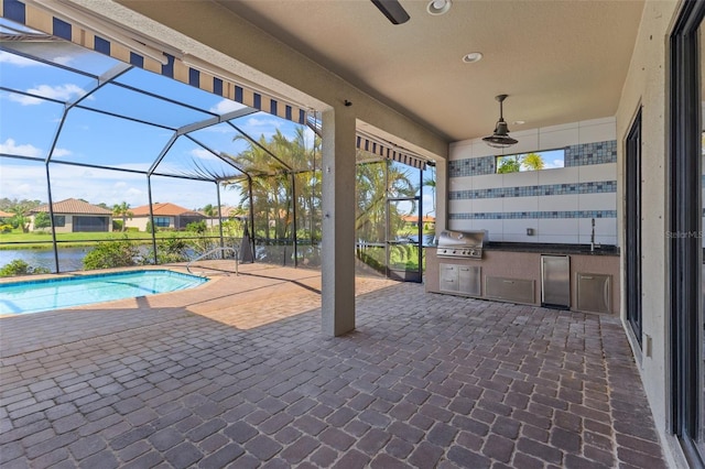 view of swimming pool featuring ceiling fan, a water view, a patio, a lanai, and a grill